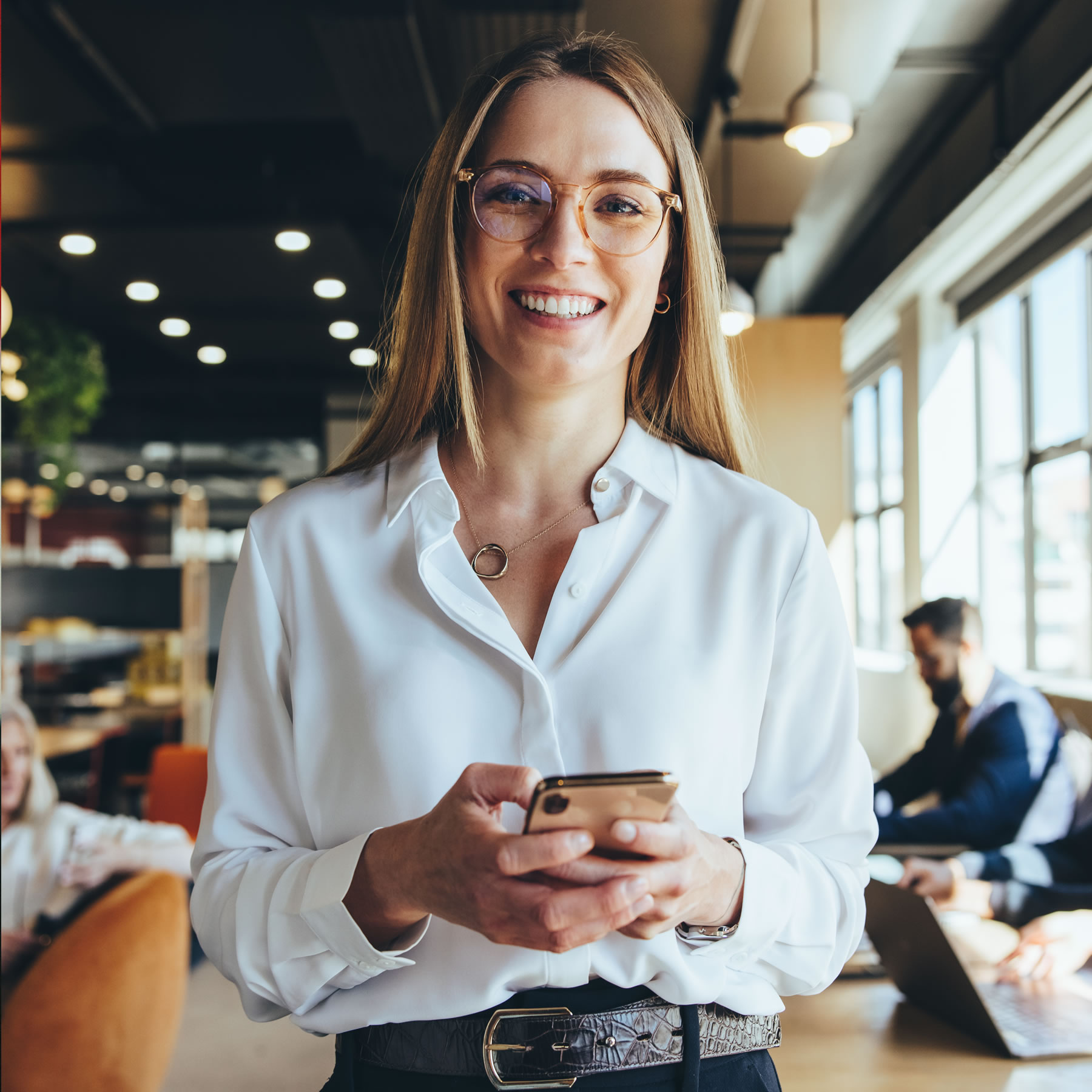 designer holding a phone, smiling to camera