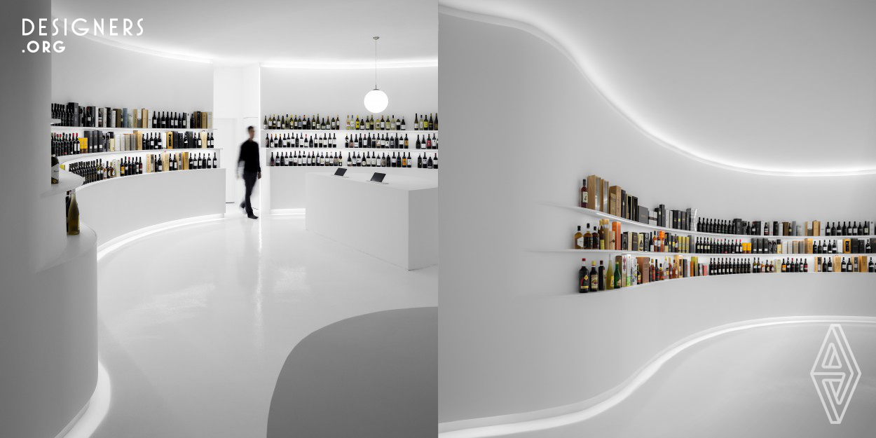 The Portugal Vineyards concept store is the first physical store for the online wine specialist company. Located adjacent to the company’s headquarters, facing the street and occupying 90m2, the store consists of an open-plan devoid of partitions. The interior is a blindingly white and minimal space with circular circulation - a white canvas for the Portuguese wine to shine and be displayed. The shelves are carved out of the walls in reference to the wine terraces on a 360 degrees immersive retail experience with no counter.
