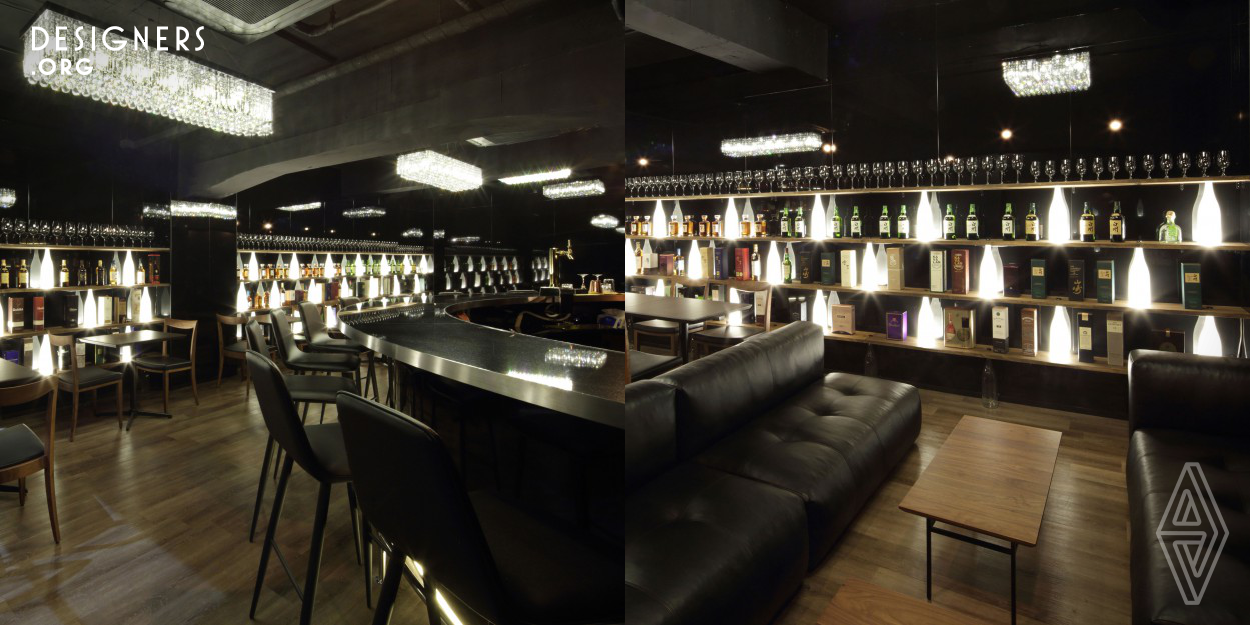 The designer was in charge from design to construction. By making it a glossy black wall, it reflects the sight and gives out mysterious continuity. The timeless atmosphere is created by giving a sense of tension to the luxury sofa and chandelier synchronized with the sharp shelves.
There is no metal joint. Just bottles that are stuck in the shelves. Lighting fixtures are embedded in the shelves (thickness 18mm) to light from below. There are many beautiful things and fun things around us. Ingenuity is the key. The Japanese Sake bottles support the world's liquors as shelf structure.