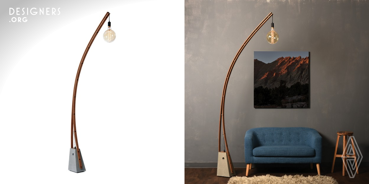 The Outer Borough Lamp (OBL) is a free standing modular floor lamp composed with one high-strength cast and polished concrete base and a two-piece steam-bent wooden arm that supports a pendant luminaire. The base geometry has sharp edges and a low center of gravity with a hole at the centroid for lifting and moving. Its shape is sloped to receive the two-piece wooden arm that attaches at the front & back of the base before sloping up to a 2.5 meter tall arc. A pendant fixture hangs from the top with its exposed power supply weaving down the arm to plug into the lamp base next to a switch.