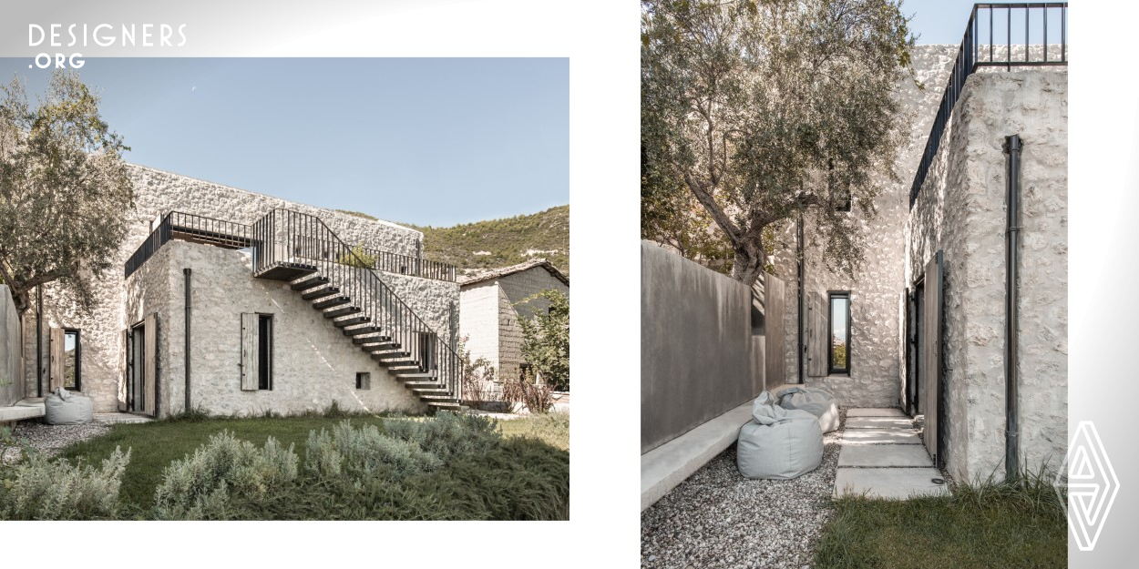 A plot situated in a remote village of Kalamia, with view to the Gulf of Corinth, is a setting for a family retreat. The morphology of the place led to the decision of creating a house with humble appearance from the street side, while developing in a two-level construction from the garden. Natural materials applied are inspired by industrial feel of the rural Peloponnese traditional stone stables. Built according to sustainable standards with restricted means, the custom-made dwelling has been playing major role in the 2020 pandemic situation, providing its inhabitants safety and comfort.