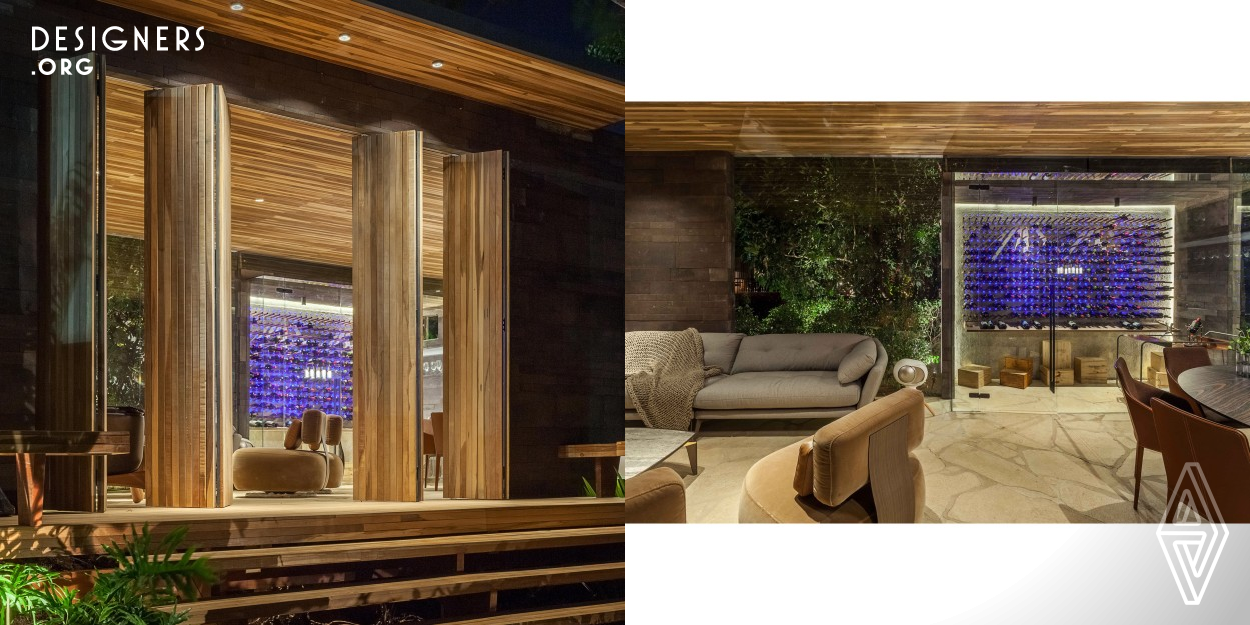 This house was designed to enhance the experience of collecting and tasting a good wine. A wine cellar in the middle of high trees in gardens of Mangabeira Palace in the city of Belo Horizonte in Brazil.  The inspiration was the true universe of wineries. In order to reproduce that, there are many natural elements such as wood, stone, of a more closed character, which covers both the external and internal walls, in addition to leather in the furniture, resulting in an ambiance of a cozy and intimate place, ideal for good stories and great wines.