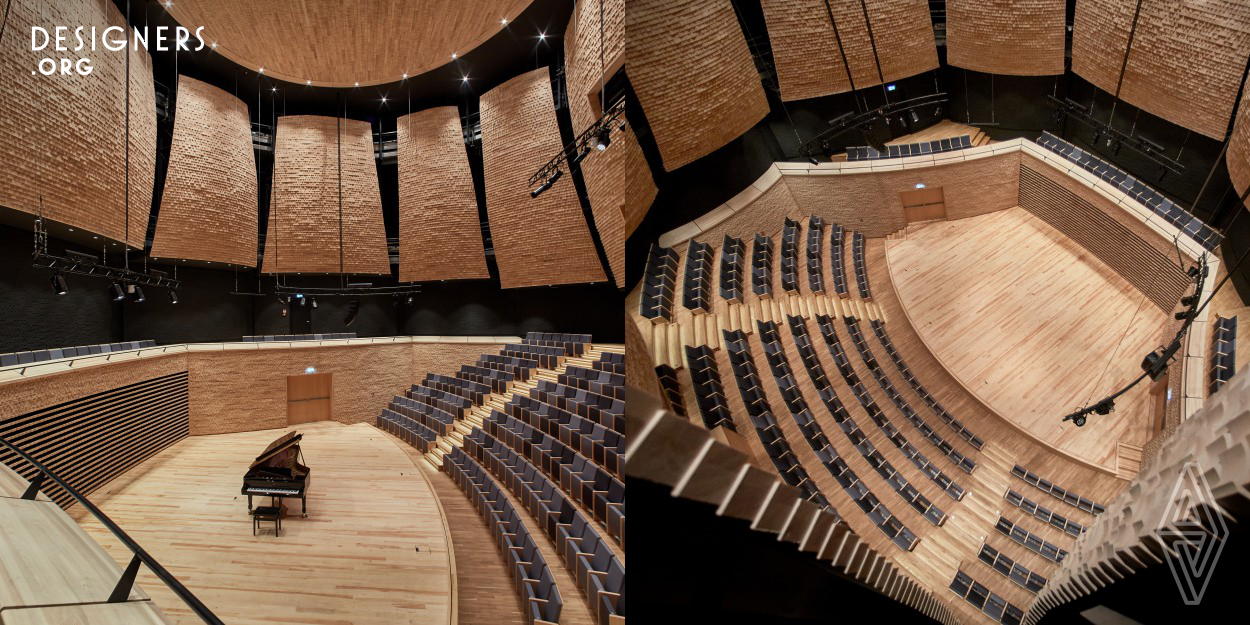 The heart of the Music School in Warsaw is a round-plan concert hall. The area divided in half between the audience and the stage allows to create a comfortable place for musicians and music lovers. The amphitheater arch surrounding young artists gives them an intimate workspace and sense of community with the audience. Wooden sail-shaped reflectors and a ceiling hanging in the hall give it a characteristic architectural expression. All of the acoustic aspects of the Konior Studio project were consulted with Nagata Acoustics.