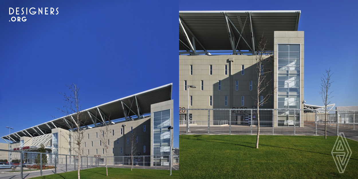 The Ael Fc Arena Football Stadium organization is based on four orthogonal tiers of seats, one of which is an extension of the building volume that hosts a number of interior spaces organized appropriately to respond to this specific use. The stadium roof system creates a set of jagged surfaces while the extensive use of glass and metal shows off an airy architecture that functions as a floodlit object during the night. Here, the unpredictable refractions of natural and artificial light on the crystalline forms create a glowing drop-scene which invites you to observe it.