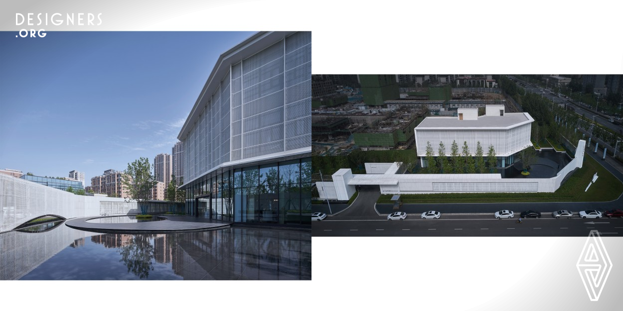 The project is located within International Eco-Aquapolis, Zhengzhou. The building echoes with the street corner through the subtly-cut blocks. It's a three-story volume, with the second and third floors lifted above the transparent block at the bottom. Taking white color as the main hue, the architects restructured the facades through the combination of points, lines and planes. The upper facades of the main building body are composed of perforated plates, while the lower parts are clad in glass, which blur the boundaries between spaces.