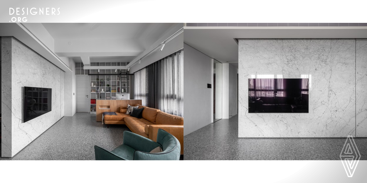 Italian grey terrazzo floorings, pebble-like artistic paints on the wall, and the white rustic stone-made television wall have highlighted the leading grey-white tone, allowing the space to emit a sense of modern and vividness. The designer has also selected decorations that add an antique-y sense to the residence. The back wall of the entryway is made of Italian handmade terrazzo and is equipped with solid wooden supports to store and display the clients bikes. 