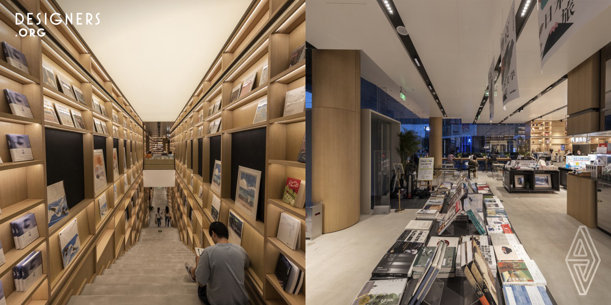 The Pageone Wudaokou bookstore is located in the Haidian district of Beijing. It is an independent construction next to the Wudaokou station of the subway line 13. The modern and irregular polyhedron facade is a composition of panels with different dimensions and shapes that mainly wrap up the second floor. The interior space is divided into high bookshelves and low book stands. The lighting design takes advantage of the light colored materials to welcome guests in a relaxed atmosphere where they can, under a warm and soft lighting, immerse themselves into an ocean of words.