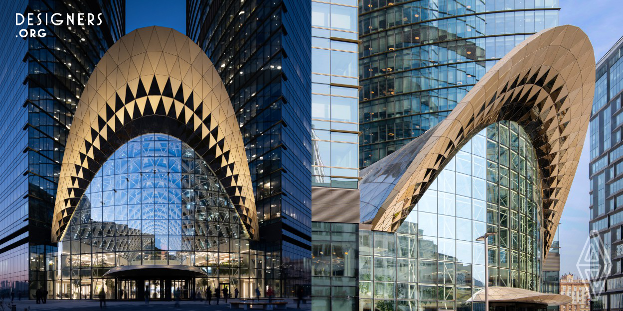 With the newly constructed building that encloses the exterior space between two existing high-rise towers the architects have created a representative entrance to the office towers that are part of Sberbank City, the new campus of the Russian bank. The hyperbolic paraboloid form delivers immense, daylight-flooded interiors, while minimizing sunlight obstruction to the offices in the towers. Both entrances are crowned in a series of triangulated panels, creating a strong design statement.