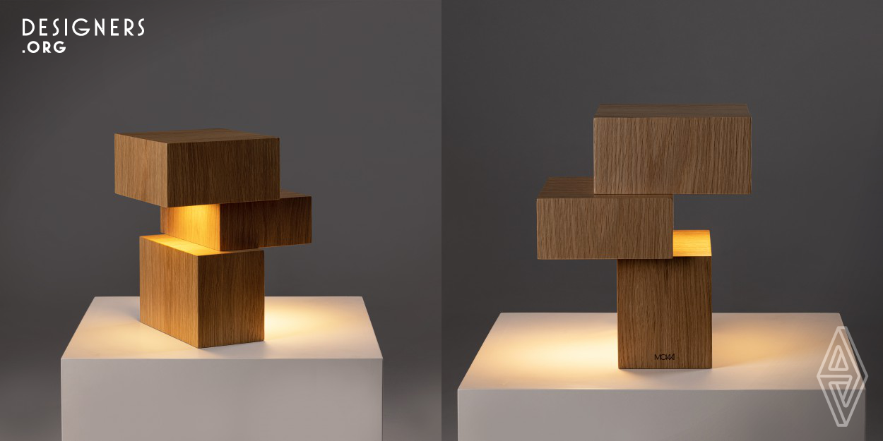 Cubes table lamp has a very clear aesthetic inspired by the architecture of the early 20th century, the Bauhaus and German modernism. Expresses a concept combining light with graphic design, a sculpture of geometric shapes. The lamp consists of three geometric forms stacked in a balanced composition and distinguished by the material, wood. The asymmetric positioning of the forms creates a different profile on each side, a constant rediscovery of the piece. The light fixture is a led circuit with a diffuser, softly distributing the light downwards on two of the volumes.