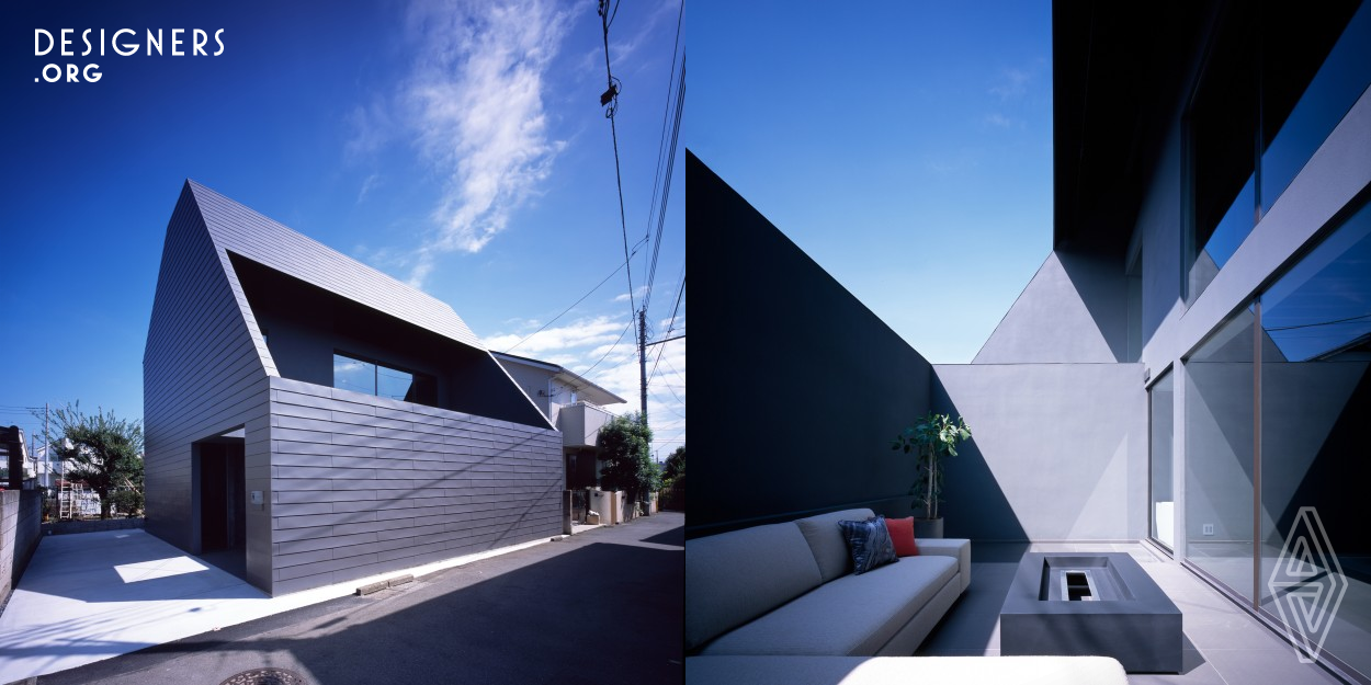 This home in a high density residential district in Tokyo's suburbs was commissioned by a designer at a large real estate company. The first floor entrance offers a view between the staircase and the bathroom clear to the back of the property. Thanks to a courtyard like layout that ensures privacy and a peaceful mood, it's hard to believe the street is just on the other side of the wall. The second floor is integrated with a loft and large void, forming a living area that takes advantage of the high ceilings.