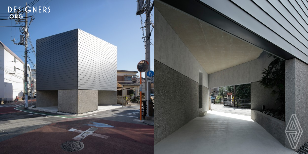 An urban house integrating floodwaters into its design. This house with a monolithic facade and a drive-through garage with a high foundation is situated on a pentagonal corner lot that is expected to be crowded with pedestrians. The design features a planar and cross-sectional openness to allow light and wind to flow into the interior while also taking into account the convenience of people and cars while deflecting water. This work explores a simple and sensible approach to future urban housing with a focus on natural disasters.