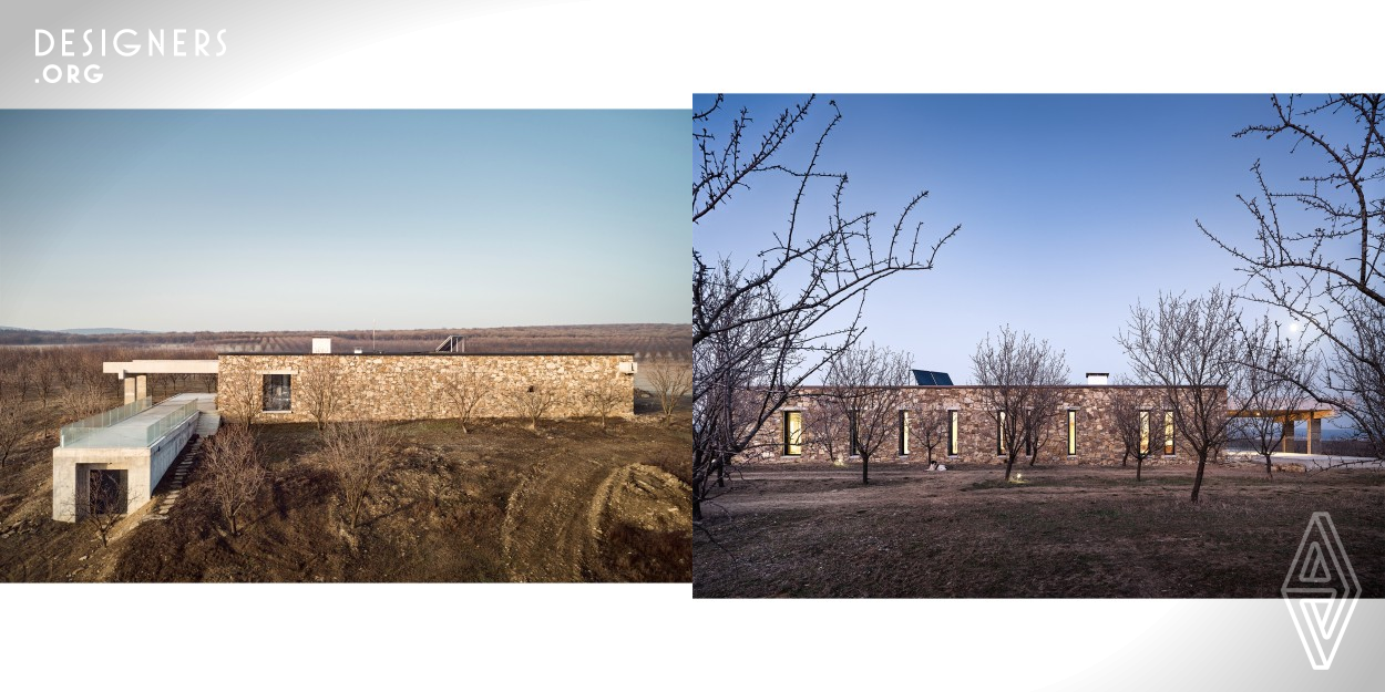 The building serves as a temporary accommodation for the workers in a fruit orchard. Project's goal was to provide ample accommodation and workspace located in an area of outstanding beauty. There are long distance views towards the Stara Planina Mountain to the north. A lake stretching to the east is a home for a number of wild birds. At Southwest lays the large orchard. The concept for the building draws clues from nuts structure with robust pair of stone wall.