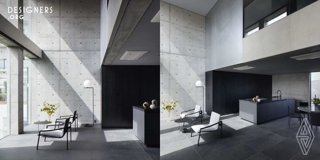 It is a refined three-story concrete exposed house located in Ashiya, Hyogo Prefecture. Due to its proximity to neighboring apartment buildings and a busy road, the emphasis was placed on blocking sightlines and noise. The design incorporates a Japanese perspective, creating a blurred relationship between the interior and exterior, with gently rising exterior walls of varying heights serving as boundaries. As one progresses along the semi-outdoor approach formed by the gaps between overlapping exterior walls, the sounds of the outside world gradually fade away.