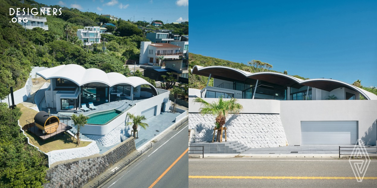 The villa overlooks a great view of the Pacific Ocean, not far from the town of Hayama, the birthplace of Japan's yachting culture. The villa's design is a sculptural form that is appropriate for this spectacular natural setting, with a vaulted roof and a series of arches that symbolize the image of the white, rippling sea. The curved arches of the CLT (cross-laminated timber) roof give a sense of spaciousness to the interior. The result is a villa that perfectly suits a laid-back lifestyle and provides a deep connection to the blue waters at its doorstep.