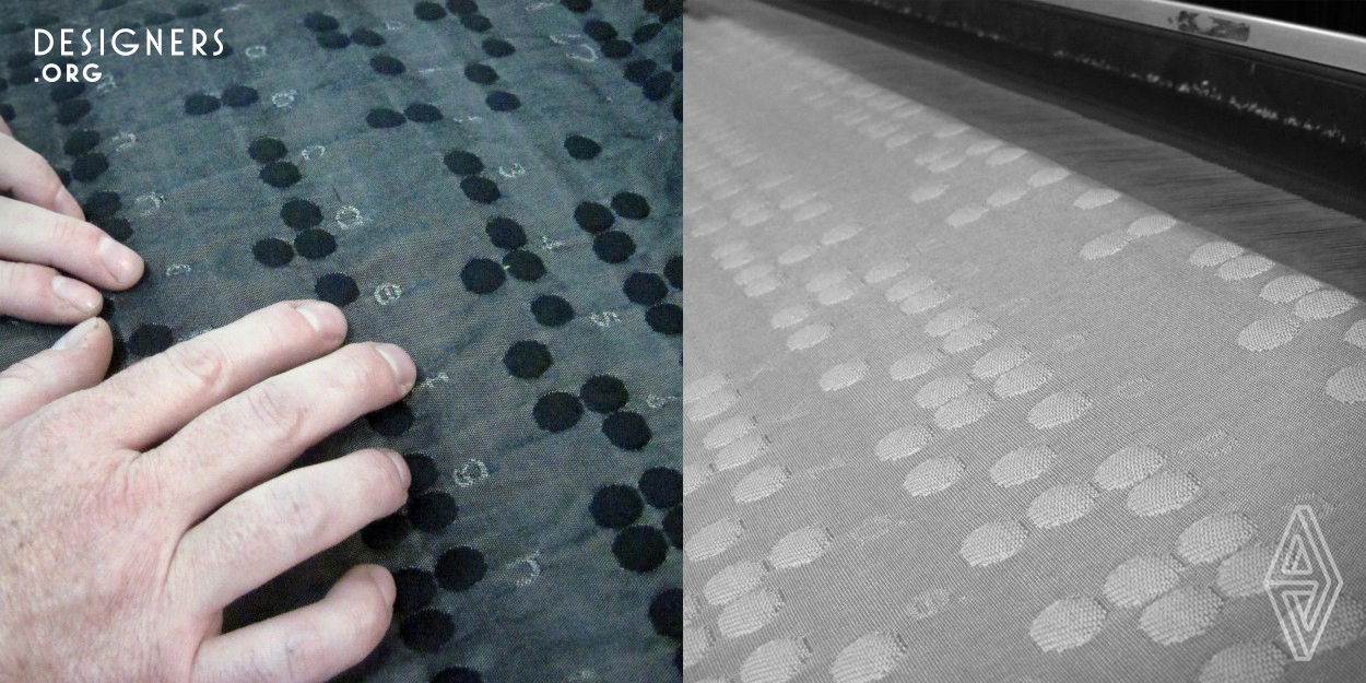 Industrial universal jacquard textile thought as a translator for blind people. This fabric can be read by people with good sight and it is intended for them to help the blind people who are starting to lose sight or having vision problems; in order to learn the braille system with a friendly and common material: fabric. It contains the alphabet, numbers and punctuation marks. No colors are added. It is a product on grey scale as a principle of no light perception. It is a project with social meaning and goes beyond commercial textiles.
