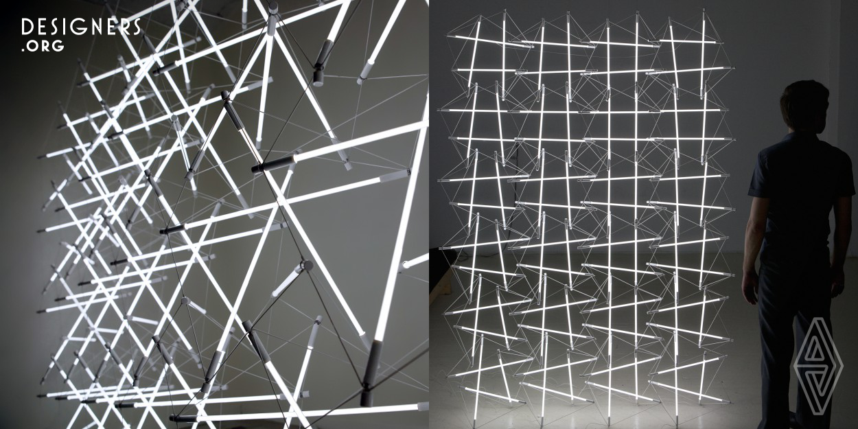 The Tensegrity space frame light utilizes R.B.Fuller's principle of 'Less for more' to produce a light fixture using only its light source and electrical wire. Tensegrity becomes the structural means by which both work mutually in compression and tension to produce a seemingly discontinuous field of light defined only by its structural logic. Its scalability, and economy of production speak to a commodity of endless configuration whose luminous form gracefully resists the pull of gravity with a simplicity that affirms the paradigm of our epoch: To achieve more whilst using less.