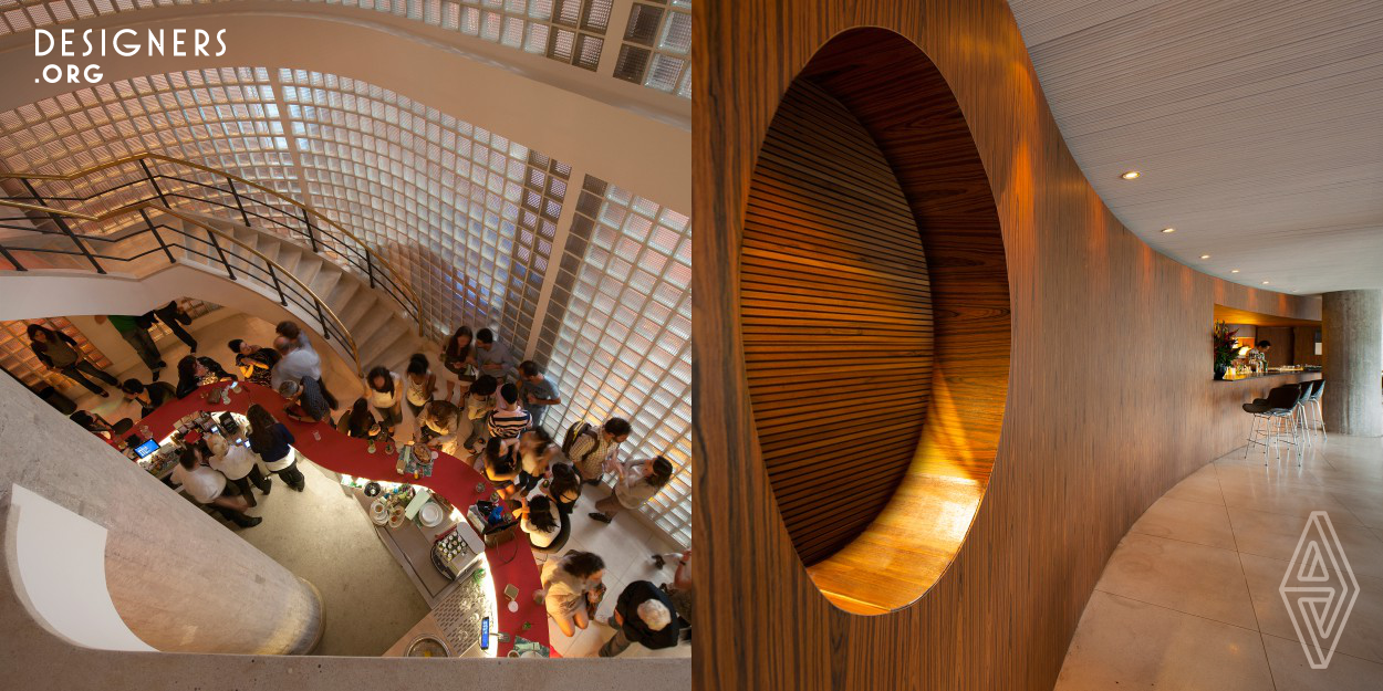 The curved lines of the glass bricks of the façade are transported to the inside. The result is a sinuous counter registered throughout the ground floor. In the center, the waiters and barmen serve the public; and around them the clients can openly see the whole space, seeing all of the people in the enclosure. Besides the counter in an organic shape, the restrooms are located on this floor as well. A sculpture-like staircase – originally from the space – takes us to the first floor, where there is the large salon on the restaurant and the kitchen. 