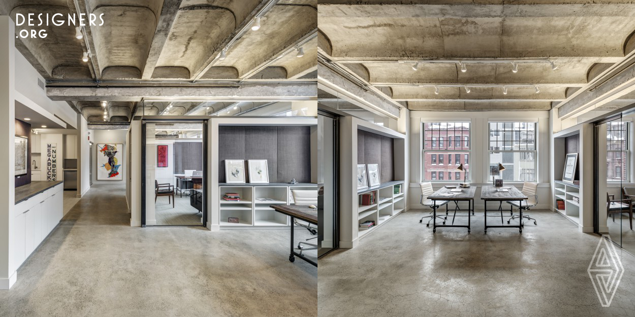 An open office plan in a historical building along Newbury Street in Boston, MA was designed for a real estate development company. The inspiration for this renovated office suite was discovered when the existing ceiling was removed and a vaulted concrete structure was revealed. This moment of realization focused the ceiling as a main design feature and evoked an architecture of connectivity between spaces. Both clerestory glass partitions and select openings allow for visual awareness of the entire interior complimented by a monochromatic material palette of steel, glass, and light woods. 