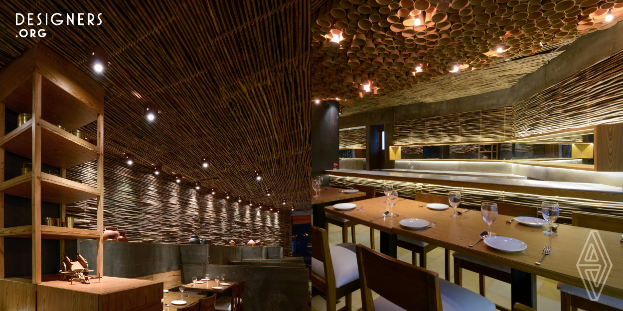This Indian Restaurant is a combination of traditional and contemporary elements. The designer has used indigenous and local material keeping in mind the local context of highway side Indian Dhaba. Cane sticks wrap the walls extending up to ceiling and central ceiling is highlighted with hanging earthen pots. The designer has used textures of natural elements to create lighting patterns. Odd shape of the premises is treated with use of mirrors. It gives international look to otherwise a normal Indian restaurant and encourages the expacts to step in and experience the Indian culture