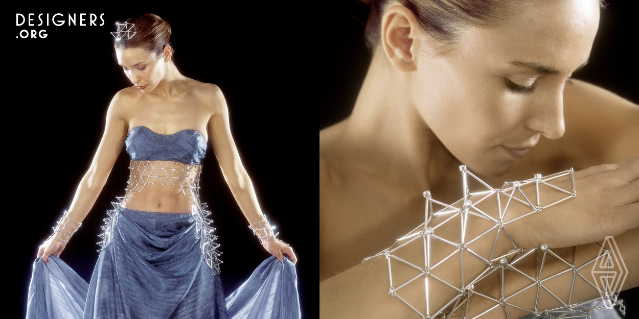 The fundamental building element of silver jewellery is the equilateral triangle and spatially, the tetrahedron. It can be found in the structure of many crystals and molecule models and combined into infinite spatial shapes. The tetrahedral structure with flexible joints forms various shapes of mobile adjustable jewellery. Despite the geometrical structure it gently follows the motion of a body. The illusion of infinite structures symbolically alludes to permanence. The gleam of the pyramidal peaks is highlighted by the embedded ground glass stones.