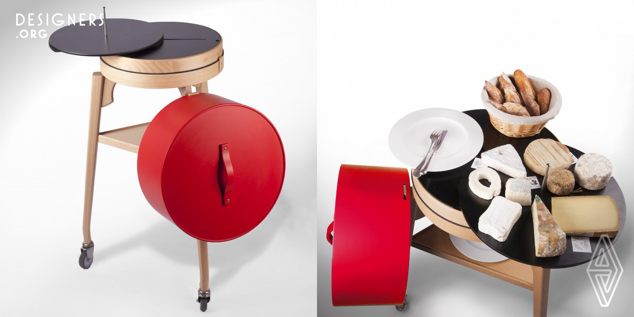 Patrick Sarran created the Coq cheese trolley in 2012. The strangeness of this rolling item excites diners' curiosity, but make no mistake, this is primarily a working tool. This is achieved by means of a stylized varnished beech structure topped by a cylindrical red lacquered cloche which can be hung at the side to reveal an assortment of matured cheeses. Using the handle to move the cart, opening the box, sliding the board out to make a space for the plate, rotating this disc to cut portions of cheese, the waiter can develop the process into a little piece of performance art. 