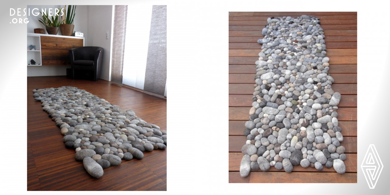 Felt stone area rug gives an optical illusion of real stones. The use of different wools complement the look and feel of the rug. Stones are different from one another in size, color and high - the surface looks like in the nature. Some of them have a moss effect. Each pebble has a foam core that is surrounded by 100% wool. On the basis of this soft core every rock squeezes under pressure. The backing of the a rug is a transparent mat. Stones are sewed together and with the mat.