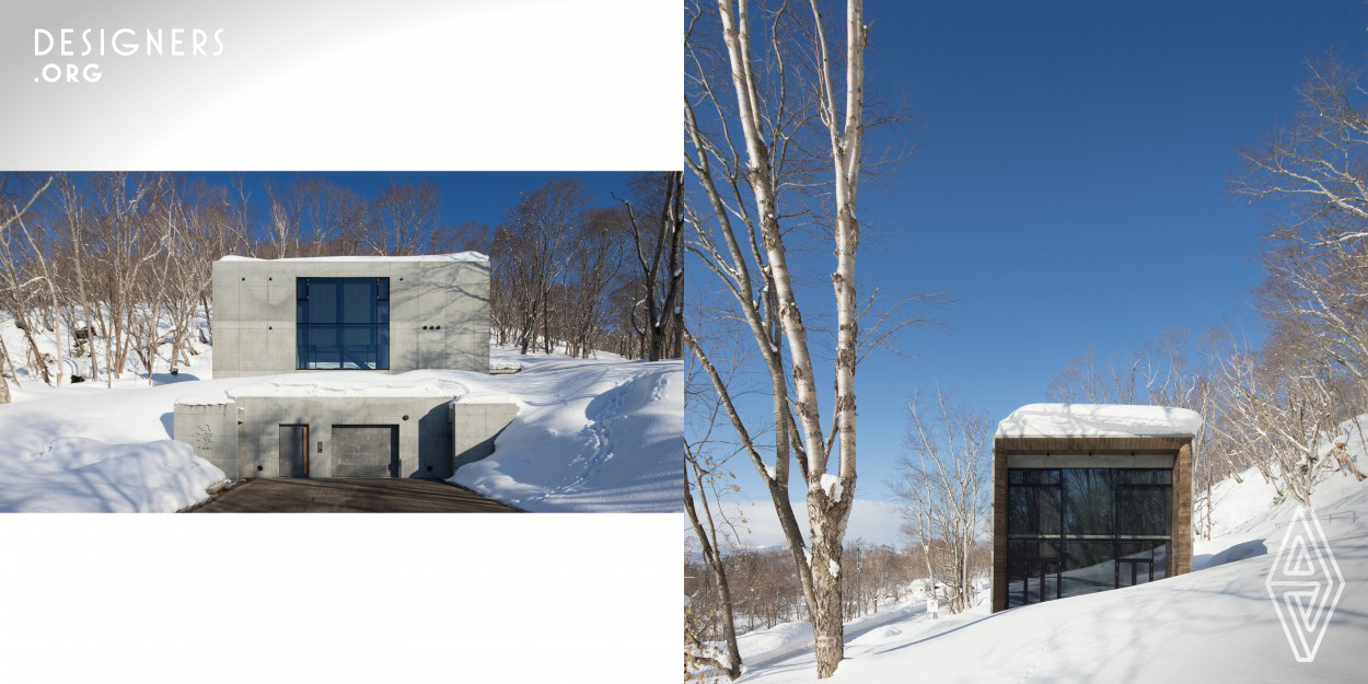 A hole is dug in the slope to insert the garage and entrance. Public spaces including the living room, dining room, and kitchen are accessible from the stairs penetrating the ground. Upon emerging out of the ground, one finds himself/herself in the living space in the resort villa, which feels like part of the surrounding nature, embraced by beautiful snow and trees. This building was named "Taki" (waterfall) by the client, inspired from the landscape design where water drawn from the nearby creek flows into the entrance approach.