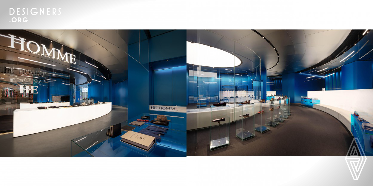 Customized business space for HE HOMME, large area of blue electro-plated aluminum is adopted, with chrome-plated glass ceiling and hot bending glass, the fixed curved steel wire is used as garment hanger rod, to display the shelves, garments, and royal blue background with the maximum penetration. Use of unique full glass display shelves as transparent partition, together with hot bending glass created a loop circulation line around the center, adding dramatic feature to space.