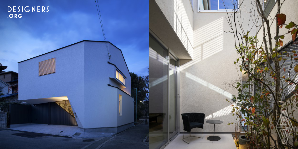 It is a house for two couples and small children built in Osaka, Japan. We have a courtyard to ensure daylighting and ventilation. The outer shape wall characterizing the appearance is the shape derived to secure the parking space. It is a shape where the parking space and the locus at the time of parking are scraped off from one block. For this reason, the shape of the outer wall gives the appearance a sharp impression.