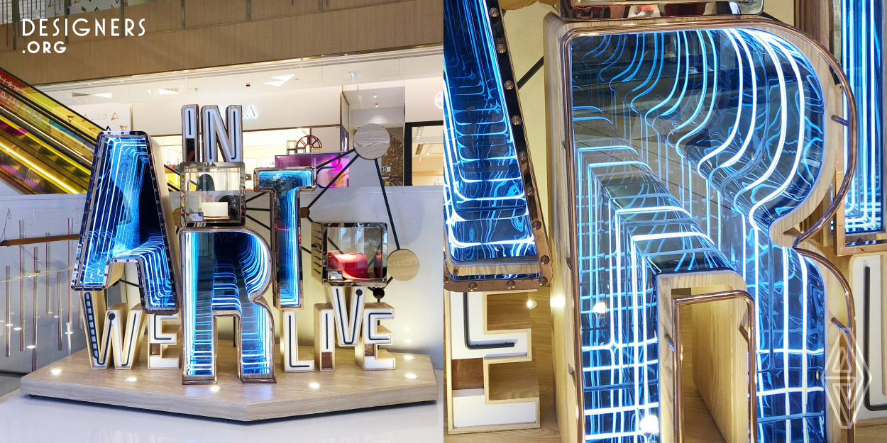 "In Art We Live" is an installation that serves as both a visual merchandising display and an art piece in Hong Kong's K11. The quote expresses K11's core values of "Art, People, Nature", bringing fine arts into a retail environment for the public to enjoy. The piece is fitted with LED lights that are programmed to change colours throughout the day, making it more alive and eye-catching for shoppers.