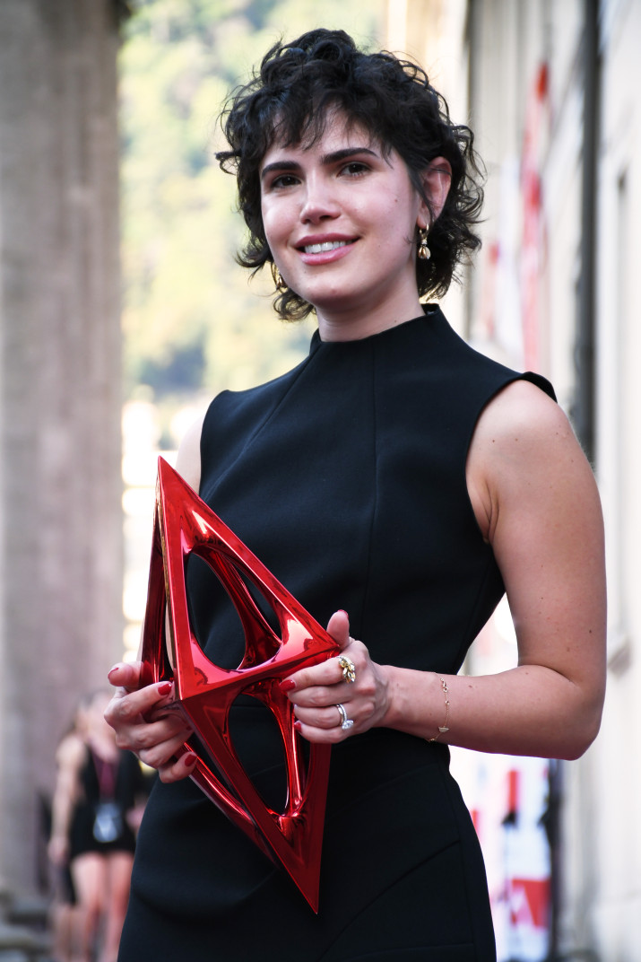 Winner holding 5XL A' Design Award Trophy