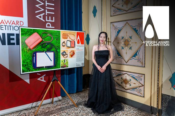 winner posing with their good design on screen